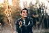 smiling man standing near green trees